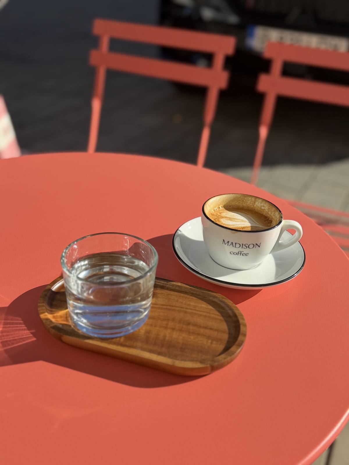 Ceașcă Madison Coffee și pahar de apă pe o masă rotundă coral